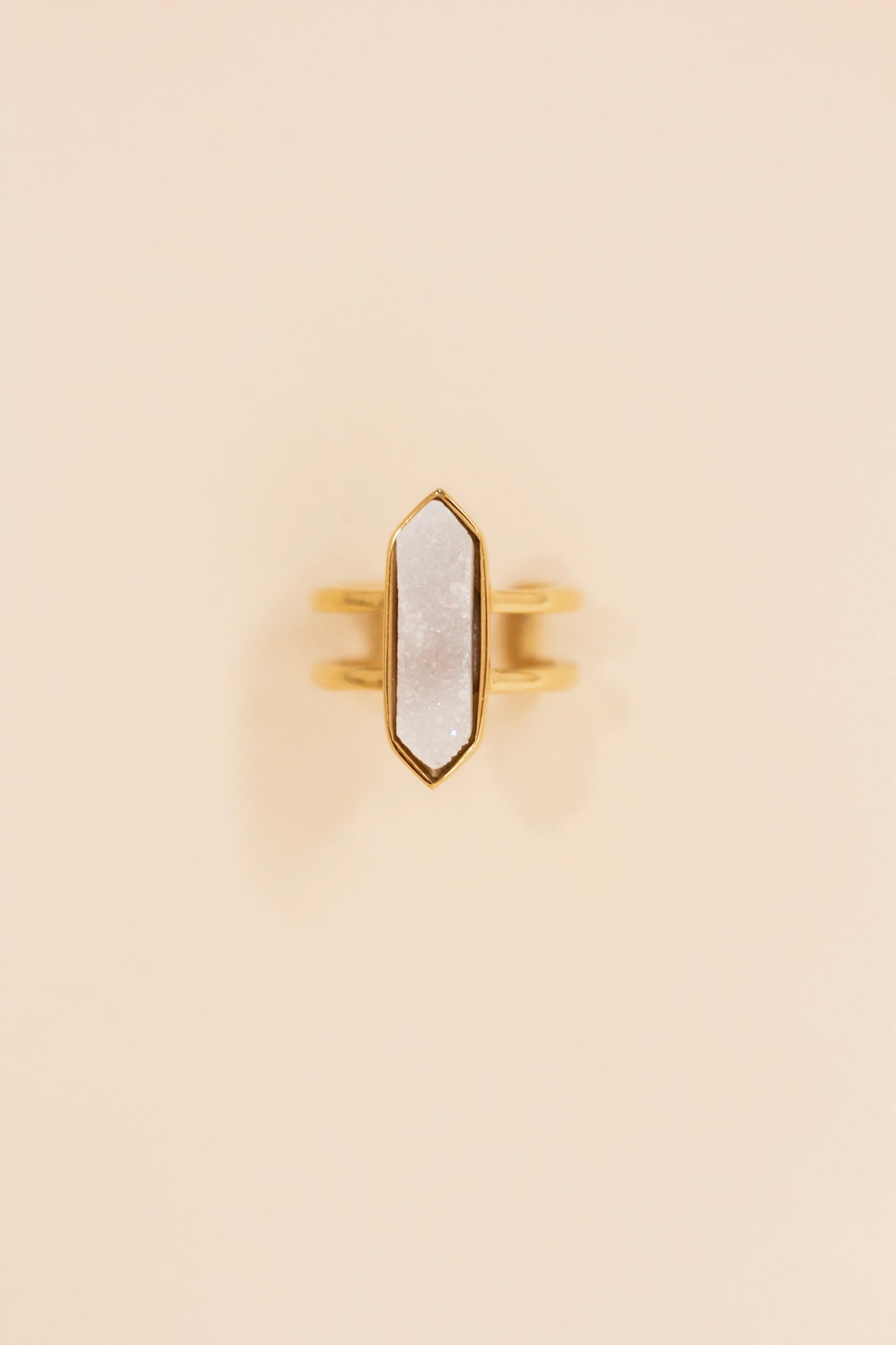 Gold double band ring featuring a large geometric white druzy stone set in a pointed bezel setting. Statement ring with a modern, boho-inspired design perfect for everyday or dressy wear.