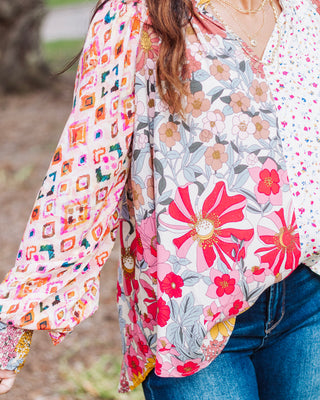 Boho floral patchwork blouse with colorful mixed prints, long balloon sleeves, and a relaxed fit, styled with denim jeans for a casual chic look.