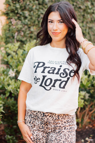 Woman wearing "Praise the Lord" Psalm 150:6 graphic tee with leopard print pants, styled outdoors—faith-based fashion at Makenzie Layne Boutique