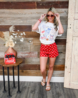 women’s patriotic graphic tee with red polka dot high waisted shorts, retro Americana boutique outfit for Memorial Day and 4th of July summer style