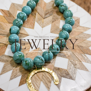 Turquoise western beaded statement necklace with gold horseshoe pendant styled for boho boutique fashion, rodeo outfits, and everyday layering jewelry.