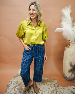 Women's chartreuse satin button-down blouse with rhinestone embellished collar and puff sleeves, paired with blue plaid wide leg pants for a polished boutique outfit perfect for work, brunch, or date night.