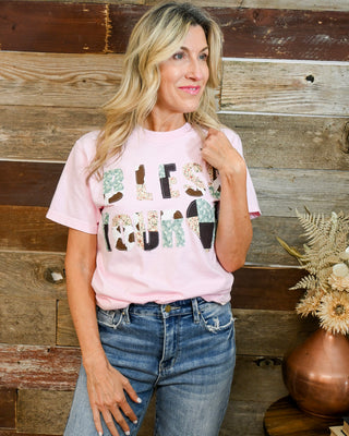 Women’s pink “Bless Your Heart” graphic t-shirt with patchwork lettering, soft casual fit, styled with high-rise denim jeans, trendy southern boutique outfit
