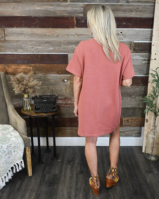Back view of a rust terracotta short sleeve shift dress with a relaxed fit and textured fabric, perfect for casual fall outfits and everyday wear.