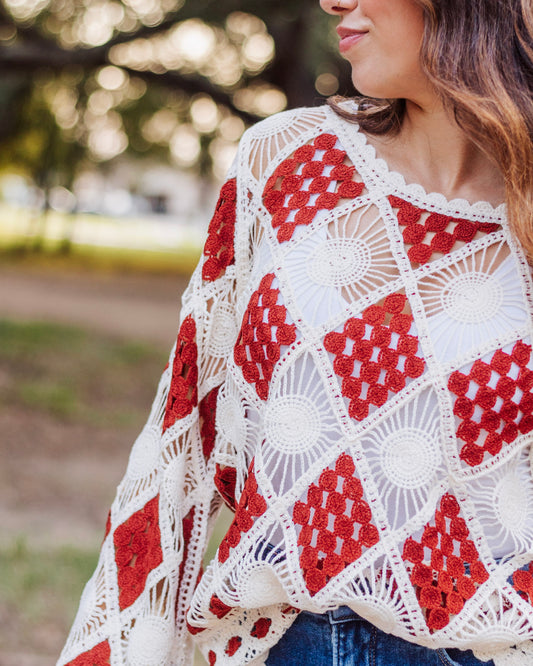 Boho crochet knit top with red and ivory square pattern, featuring wide sleeves and a lightweight open design, styled with denim jeans for a chic casual look.