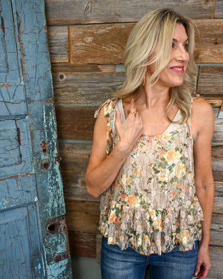Women’s taupe floral lace peplum tank with tie shoulders and ruffle hem, styled with dark wash jeans for a feminine boho boutique look
