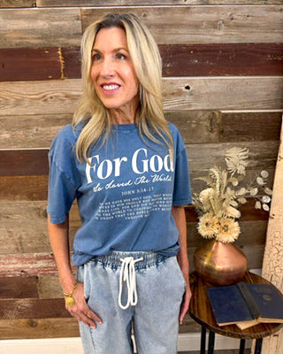 Women’s blue “For God So Loved the World” graphic t-shirt featuring John 3:16, styled with casual drawstring lounge pants, soft Christian tee, everyday faith-based outfit.