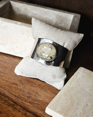 Silver-tone wide cuff bracelet with a large faceted natural stone centerpiece, blending bold statement jewelry with modern western boutique style.