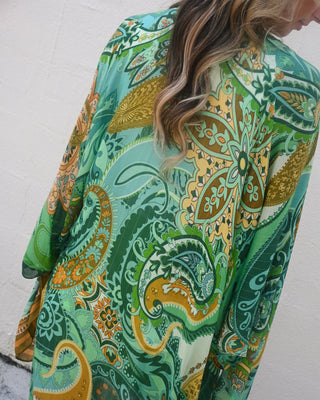 Women’s green paisley kimono with boho-inspired print and flowy silhouette, perfect for layering over denim and basics for effortless boutique style.