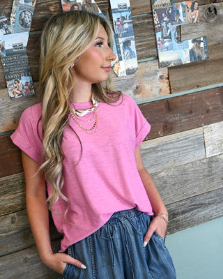 Women’s pink short sleeve top styled with high-waisted denim skirt, lightweight casual blouse, relaxed fit summer outfit, boutique fashion with layered necklace detail.