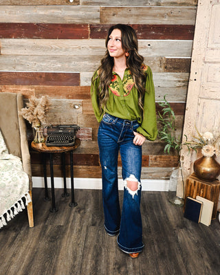 Olive green floral yoke blouse with long sleeves and button front, styled with dark wash distressed flare jeans for a feminine western fall outfit.