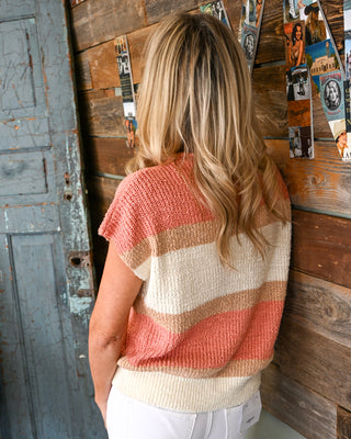 Coral, tan, and cream striped short sleeve knit sweater top on a woman, styled with white pants, lightweight spring sweater, casual boutique fashion, textured knit detail, back view.