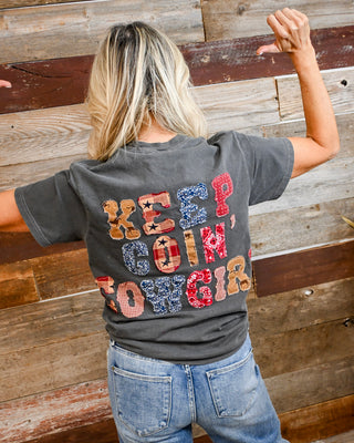 Women’s charcoal gray “Keep Goin’ Cowgirl” graphic t-shirt with patchwork western lettering on back, styled with denim jeans, casual country boutique outfit