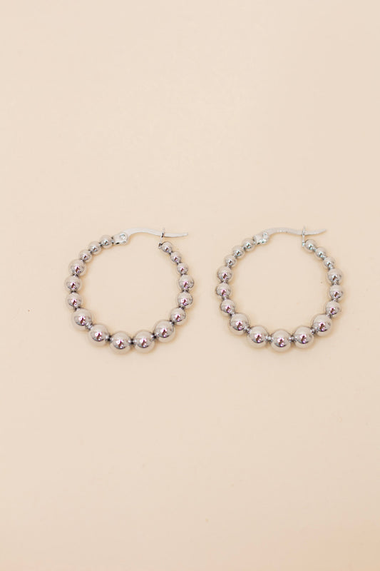 Pair of silver beaded hoop earrings featuring polished metallic round beads and a latch-back closure. Lightweight, trendy jewelry for everyday wear or special occasions.