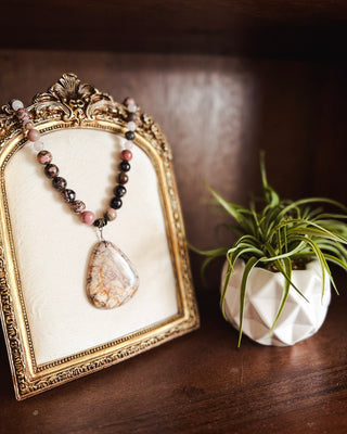 Women’s beaded statement necklace featuring pink, black and neutral stone beads with a large natural stone pendant for a boho western look.