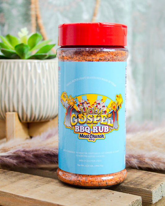 Meat Church Holy Gospel BBQ Rub, 12.5 oz bottle with vibrant blue label and bold cartoon design—MSG and gluten-free blend at Makenzie Layne Boutique