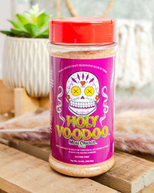 Jar of 'Holy Voodoo' meat tenderizer on a wooden surface with a blurred background