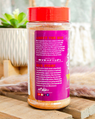 Bottle of seasoning with a red lid and purple label on a wooden surface.