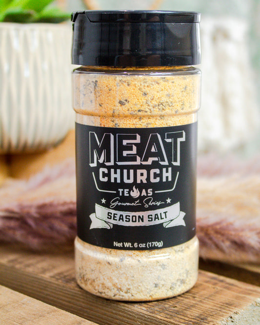 Bottle of Meat Church seasoning salt on a wooden surface with blurred background