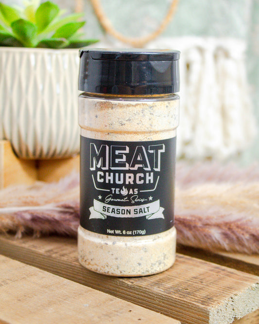 Jar of Meat Church seasoning on a wooden surface with a blurred background