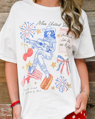 Women’s graphic tee with patriotic western design, cowgirl with guitar, fireworks, stars and cherries, oversized white t-shirt, Memorial Day or Fourth of July boutique outfit
