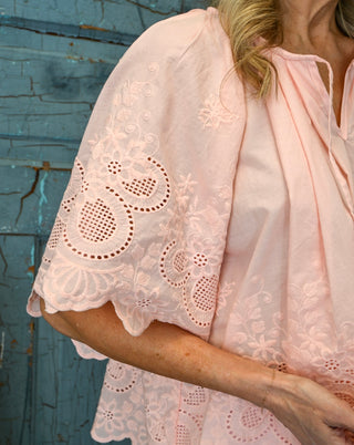 Women’s blush pink embroidered blouse with floral eyelet detail, scalloped short sleeves, and lightweight flowy fit for a feminine boutique look