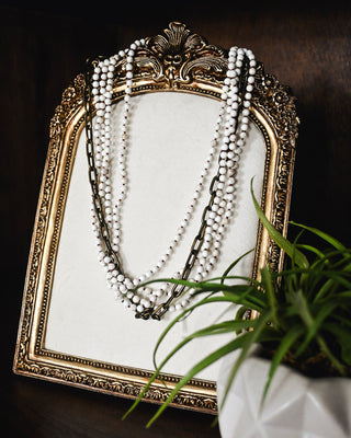 Layered white howlite beaded necklace with antique gold chain accents, featuring a multi-strand design for a chic boho western statement look.