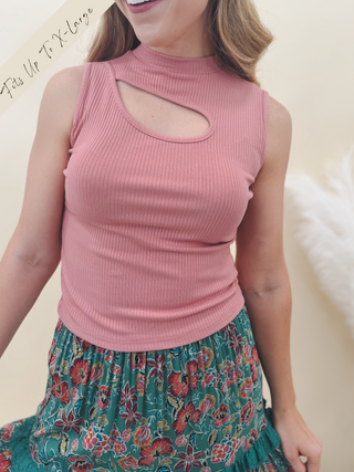 Woman wearing a ribbed mauve sleeveless top with a front keyhole cutout, paired with a green floral tiered skirt.