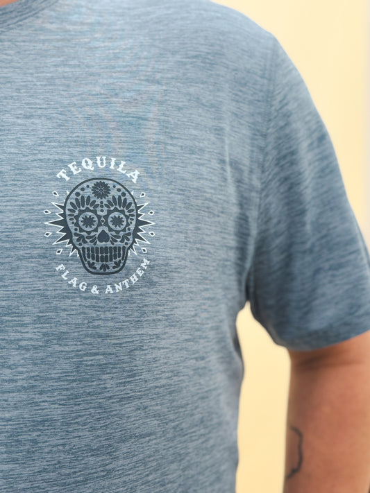Close-up of blue Flag & Anthem t-shirt featuring a white sugar skull graphic and "Tequila" text detail on soft heathered fabric.