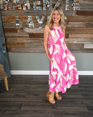 Women’s pink and white abstract print midi dress with halter neckline, tiered ruffle hem, and flowy silhouette for a bold boutique look