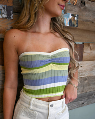 Women’s strapless ribbed knit crop top with green, blue, cream, and white stripes, styled with white high-rise shorts for a fresh boutique summer look