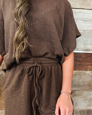 Women’s chocolate brown textured matching set featuring a relaxed short sleeve top and high-rise drawstring pants for an elevated casual fall outfit.