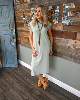 Women’s sage green midi dress with cap sleeves and relaxed fit, styled with a tassel necklace and platform sandals for an effortless boho boutique look