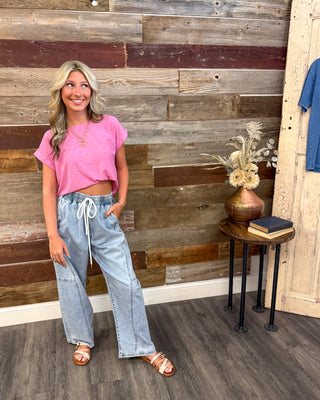 Women's casual pink crew neck tee paired with light wash drawstring wide leg denim pants, featuring a relaxed fit, pockets, and effortless everyday boutique style.