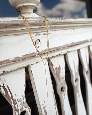 Delicate gold layered Y necklace featuring multiple dainty chains, tiny gold bead accents, and a long drop pendant, perfect for effortless everyday layering at MaKenzie Layne Boutique.