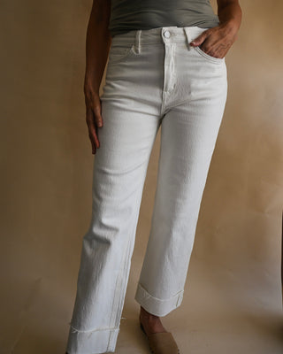Women's high-rise white straight leg jeans with cuffed raw hem detail, premium stretch denim, and a flattering ankle-length fit. Classic boutique white denim for everyday styling.