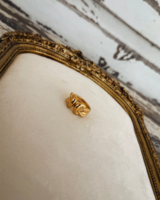 Close-up of a chunky gold statement ring featuring an intertwined chain link design with textured detailing, a trendy accessory from MaKenzie Layne Boutique.
