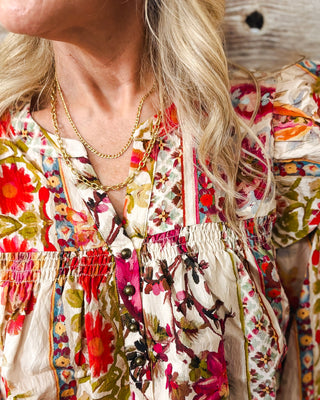 Women's layered gold chain necklace featuring a delicate twisted chain and bold oval link chain, styled with a colorful floral blouse for a trendy boho-chic look at MaKenzie Layne Boutique.