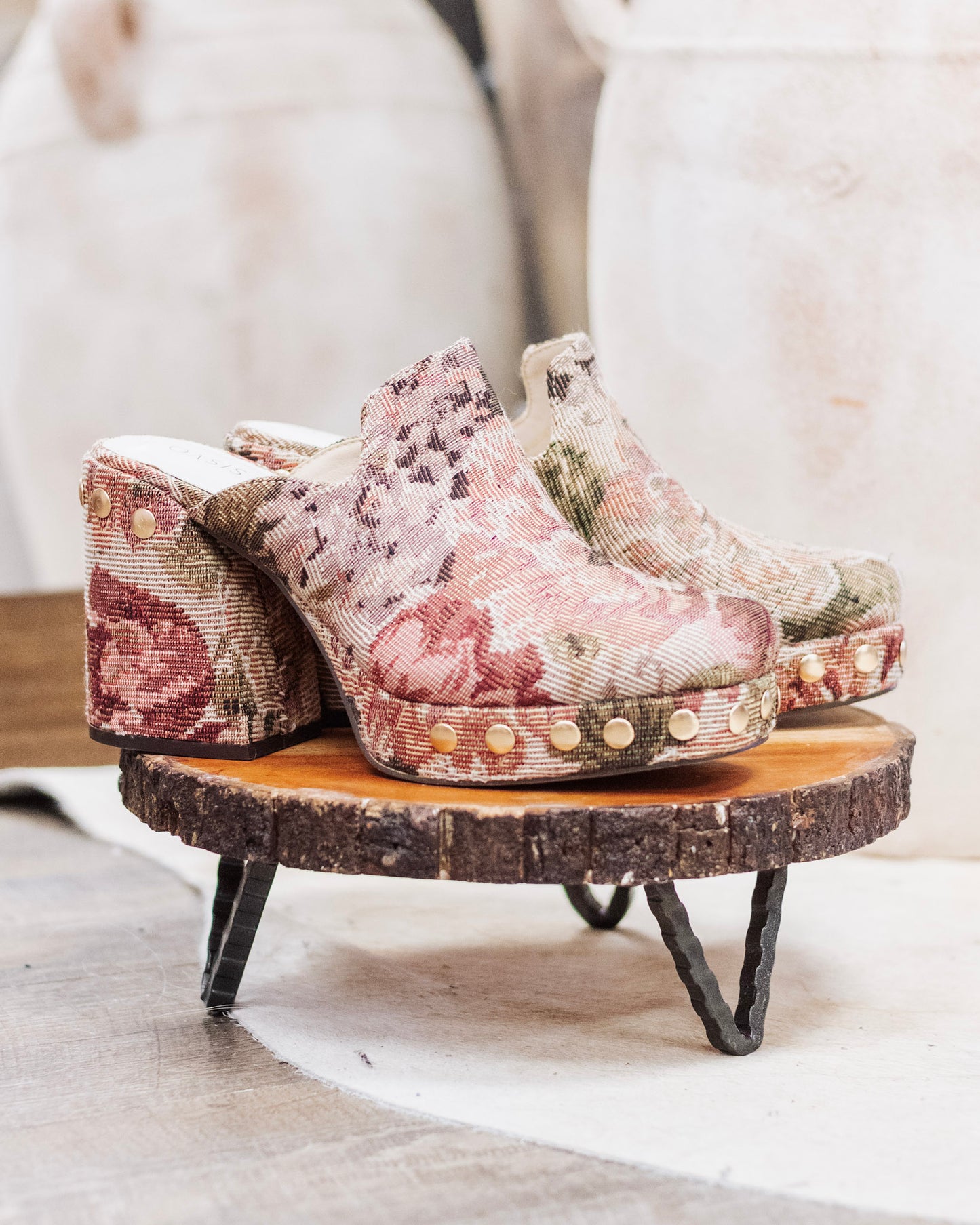 Close-up of brown and pink floral tapestry heeled mules with gold studs