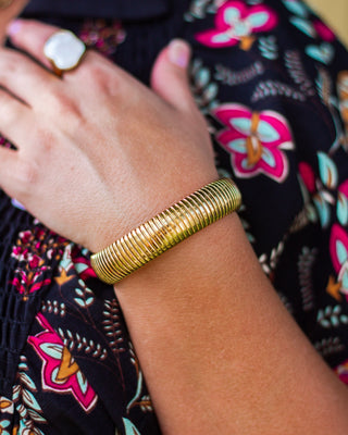Close-up of a gold ribbed stretch bracelet adding a chic, timeless accent to a boho floral outfit—perfect for boutique-inspired everyday style.