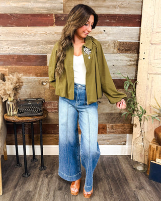 Women’s olive green cropped jacket with balloon sleeves and zip front, styled with a white tank and high-rise wide leg jeans for a chic fall outfit.