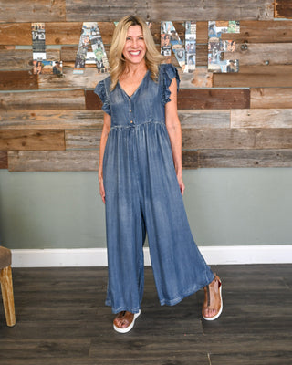 Women’s chambray wide leg jumpsuit with flutter sleeves, button front detail, V-neckline, and flowy relaxed fit for an effortless boutique look