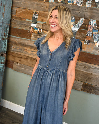 Women’s chambray jumpsuit with flutter sleeves, button front detail, V-neckline, and relaxed wide leg silhouette for an effortless